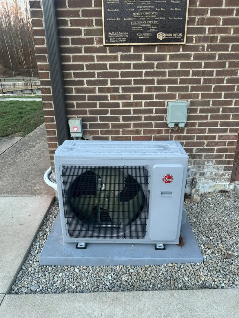 Outdoor heat pump installed beside a brick home in Preble County