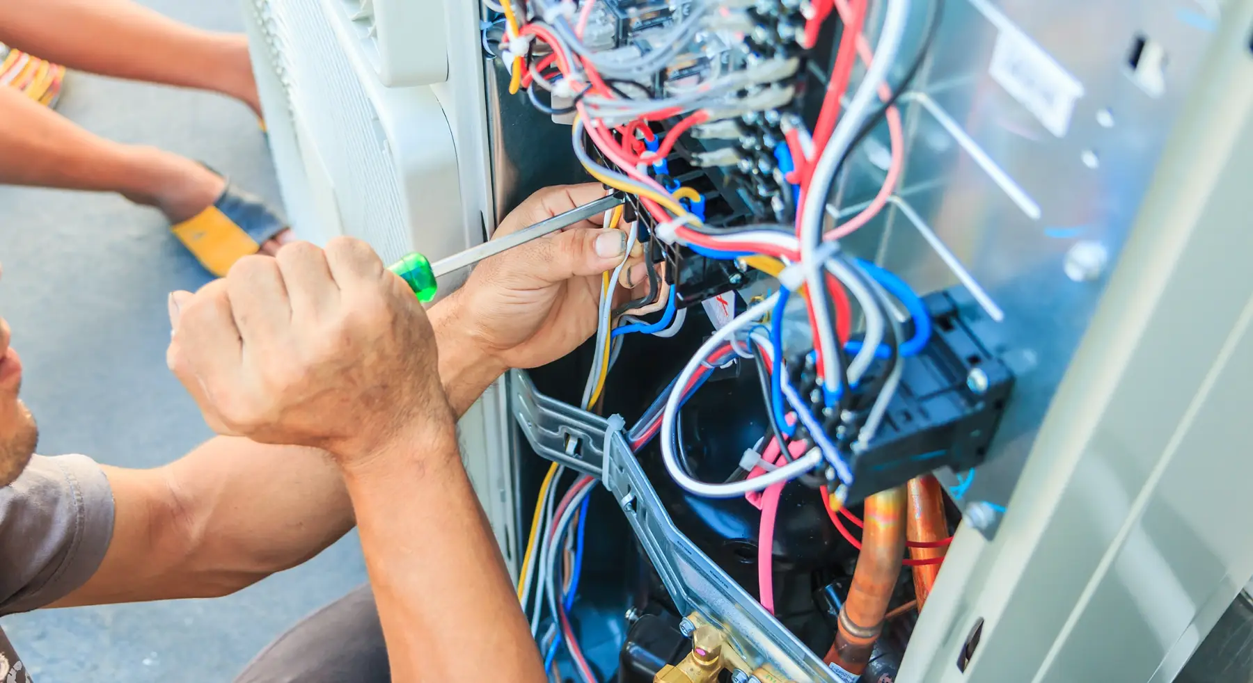 HVAC technician servicing an outdoor AC unit in New Paris, OH